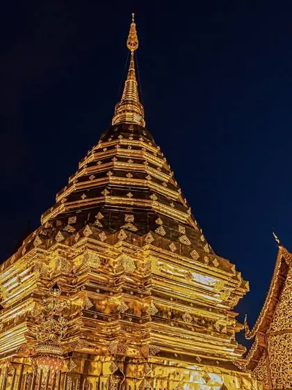 A golden Lanna chedi lit at night
